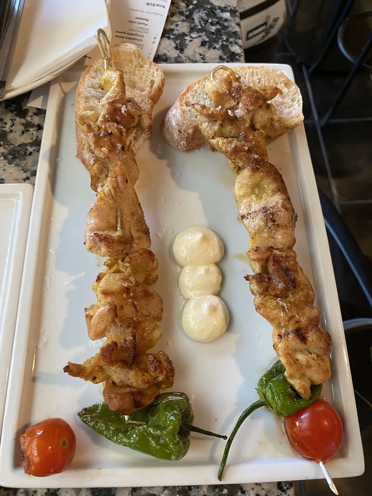 Grilled chicken skewers with peppers, onion, and cherry tomatoes on a plate
