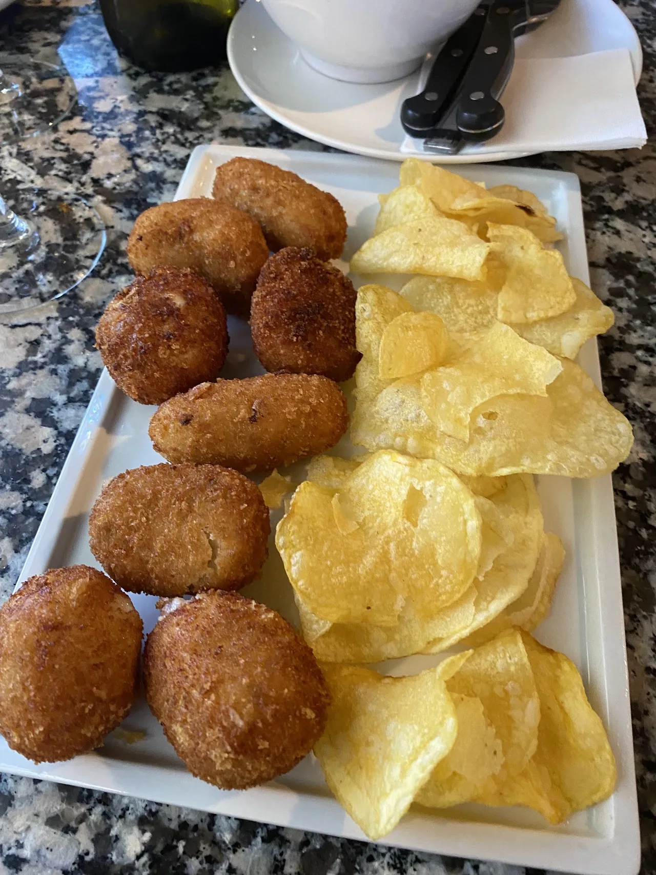 A plate of fried croquettes with potato chips