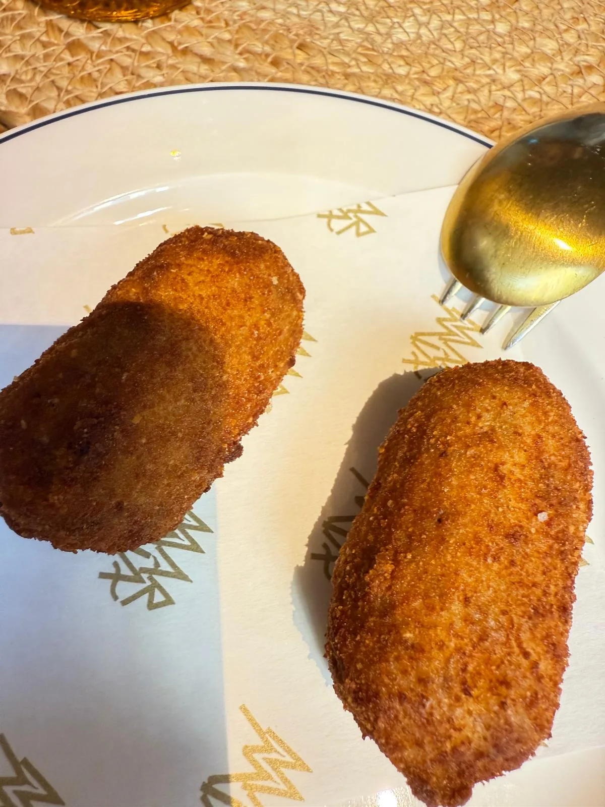 Two breaded croquettes on a plate