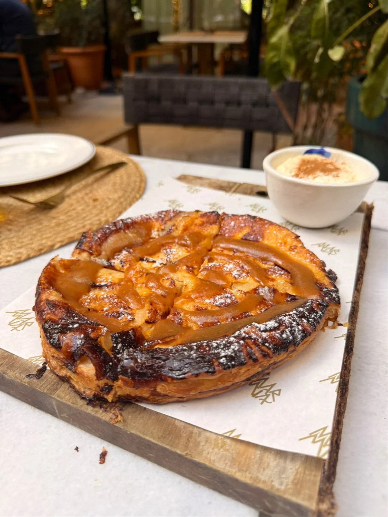A caramelized apple tart on a wooden board