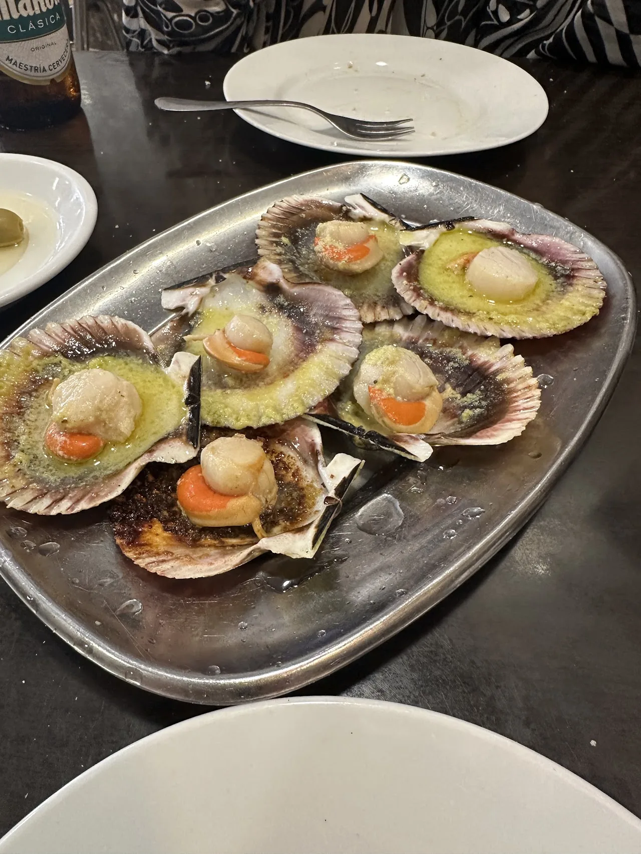 Grilled scallops served in their shells on a platter