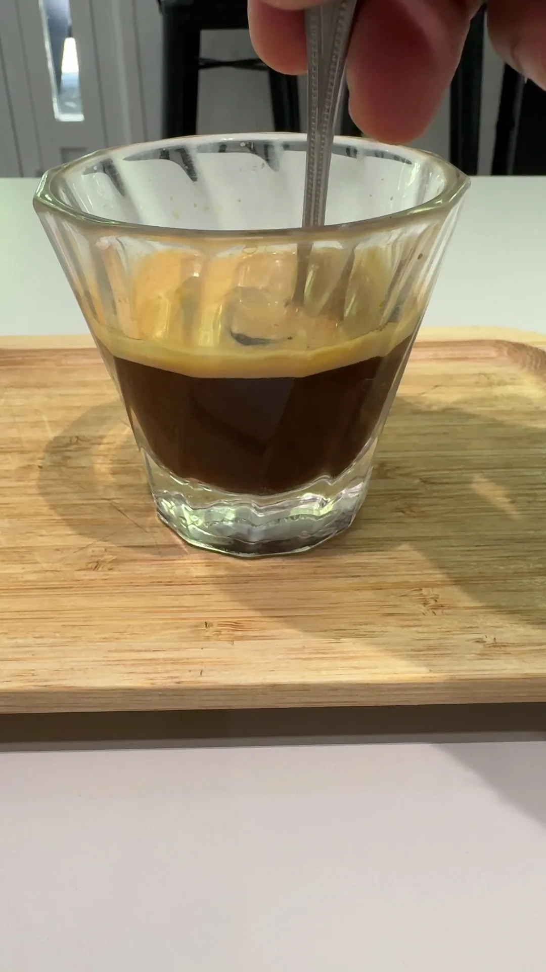 A shot of espresso in a small glass with a spoon