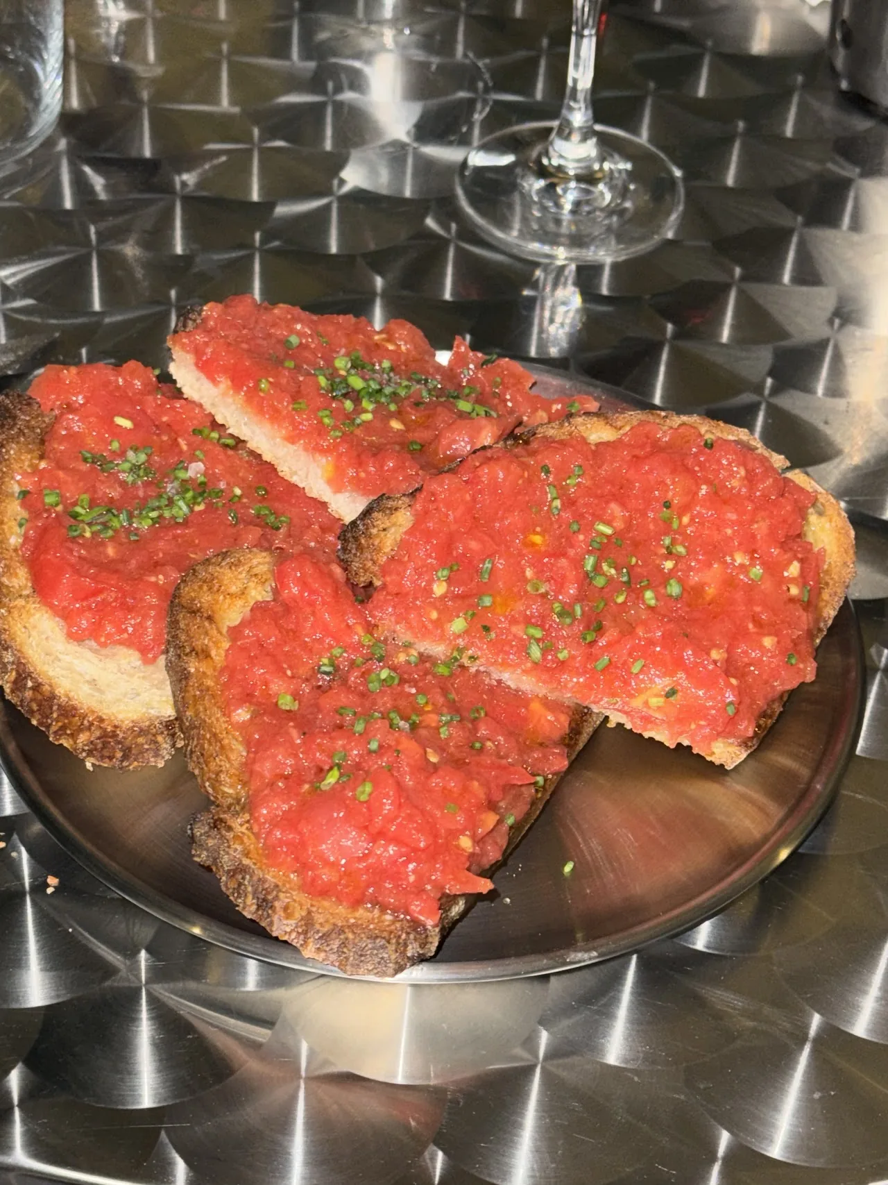Slices of tomato bread topped with olive oil and chives