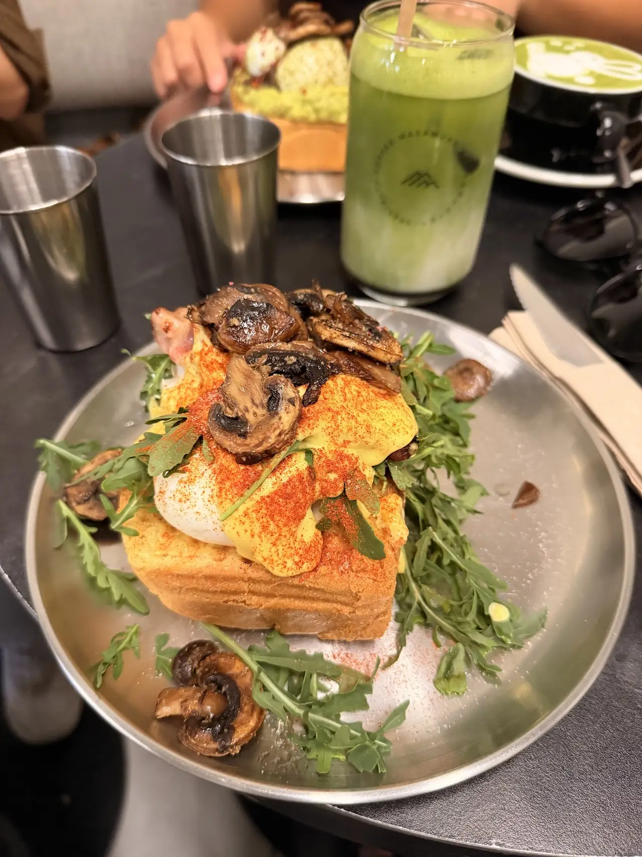 An open-faced sandwich topped with sauteed mushrooms and arugula