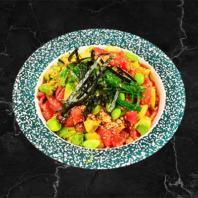 Poke bowl with cubed tuna, avocado, edamame, shredded nori and scallions in a speckled teal bowl