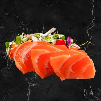 Three pieces of salmon nigiri sushi with microgreens on a dark marble surface