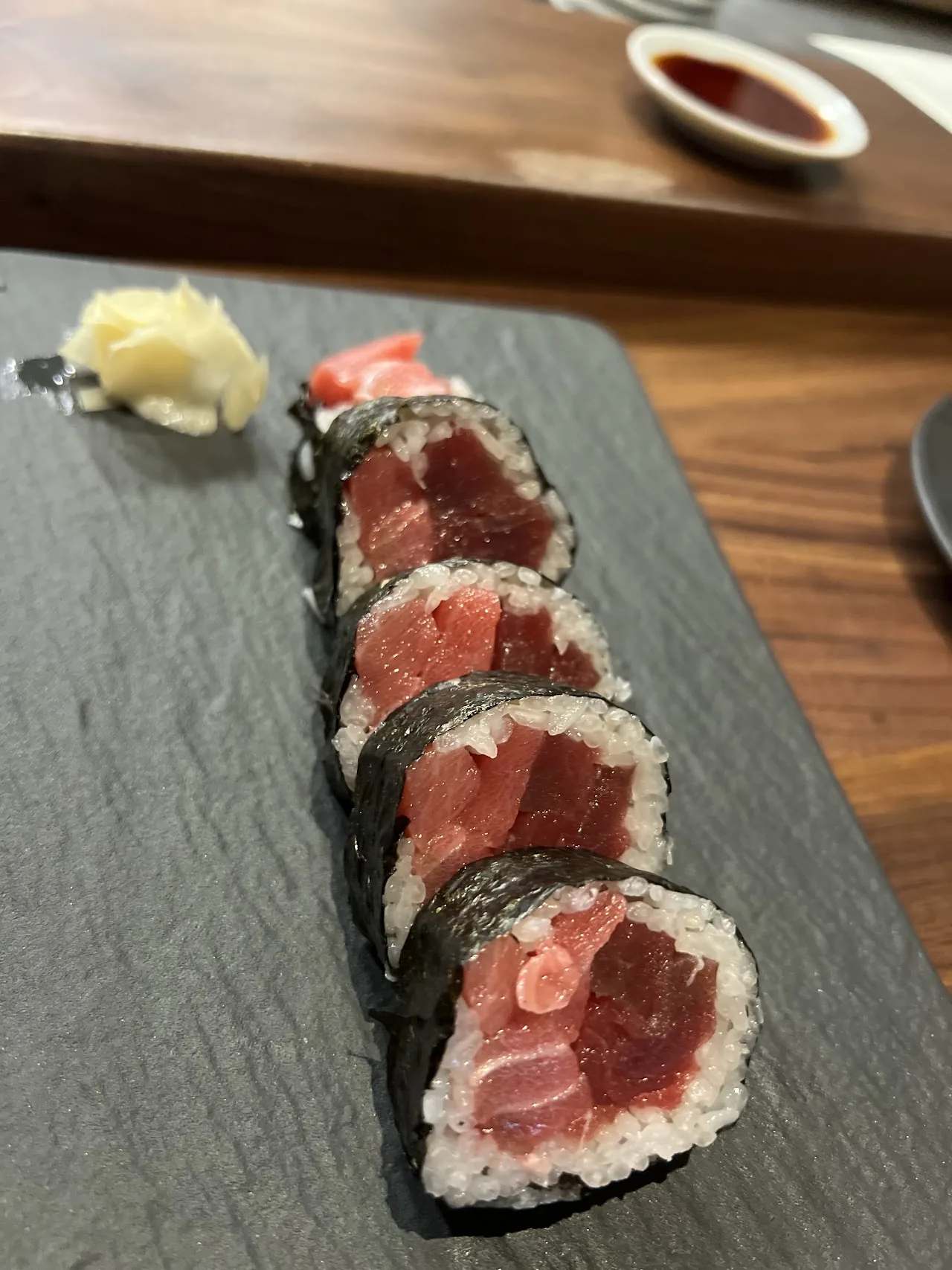 Maki sushi rolls with tuna, sliced and arranged on a slate board