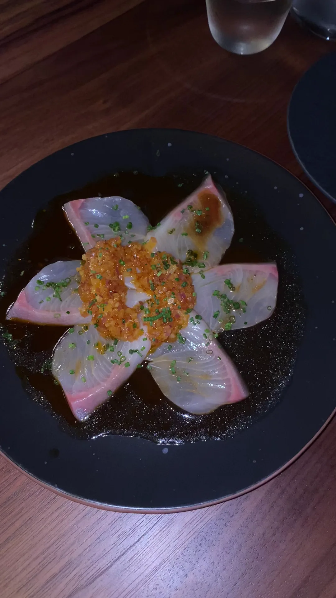 Sashimi slices arranged in a flower pattern with roe garnish