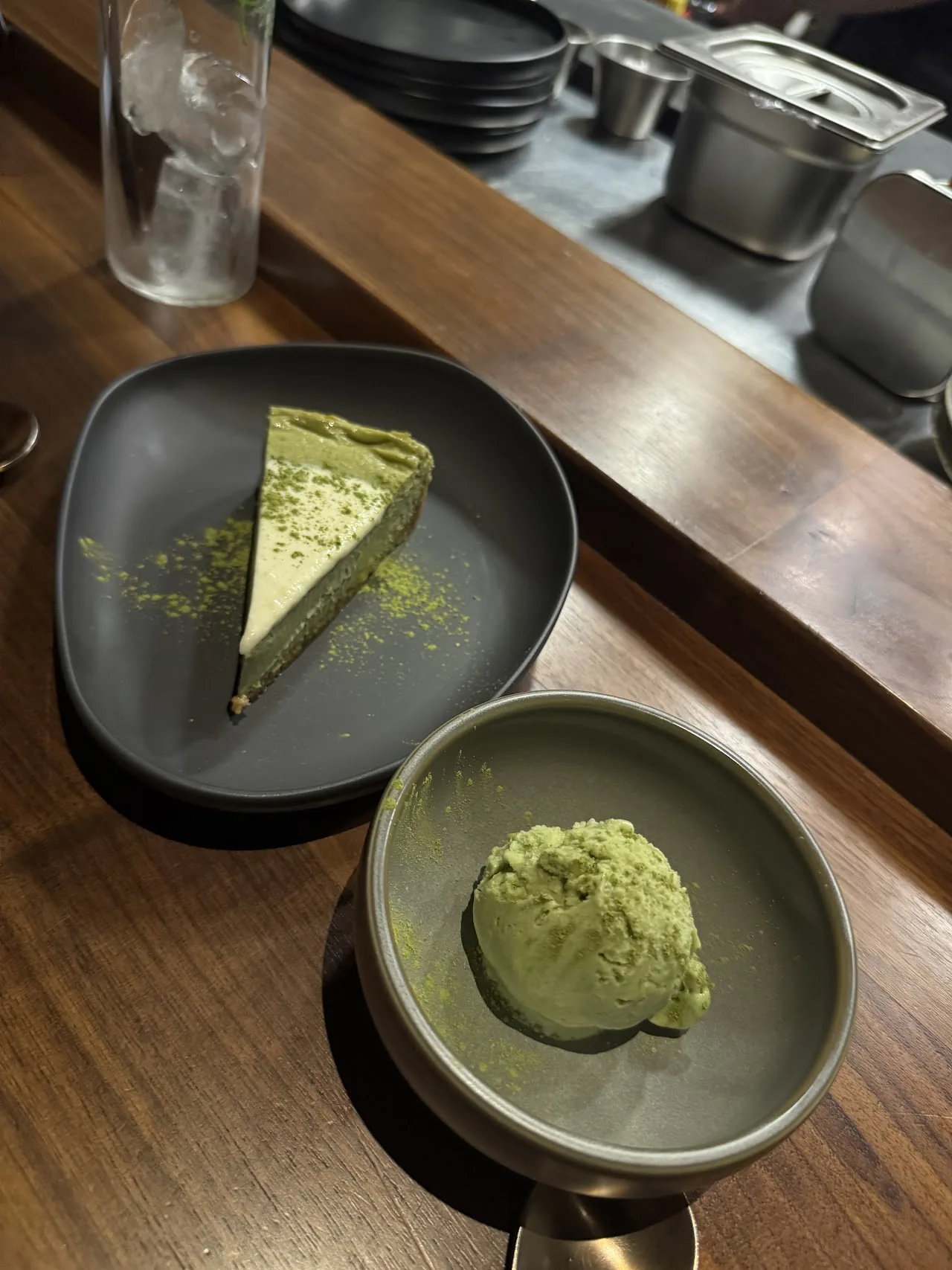 A slice of matcha cake beside a scoop of matcha ice cream