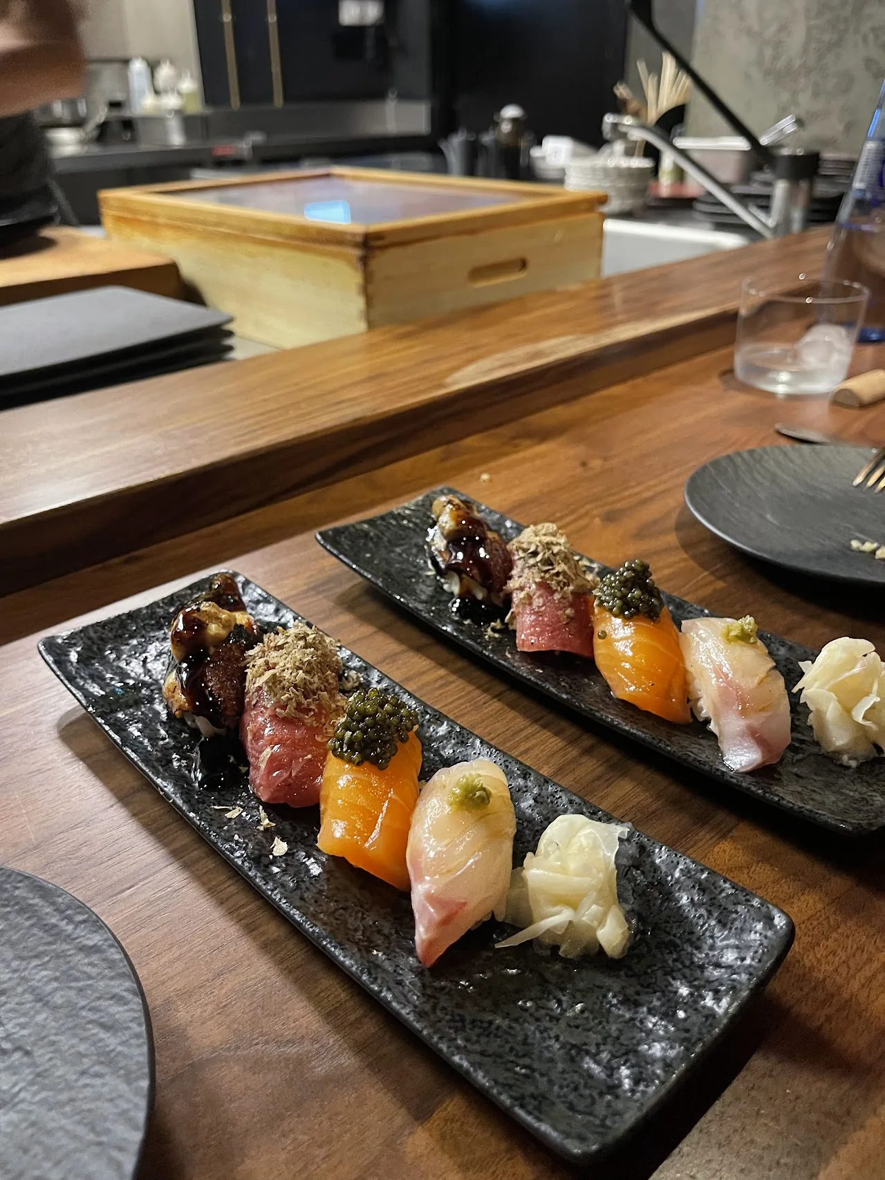 An assortment of nigiri sushi on a dark platter