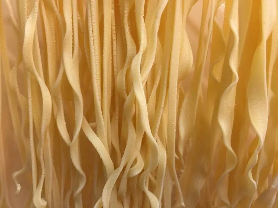 Close-up of fresh handmade tagliatelle pasta hanging to dry