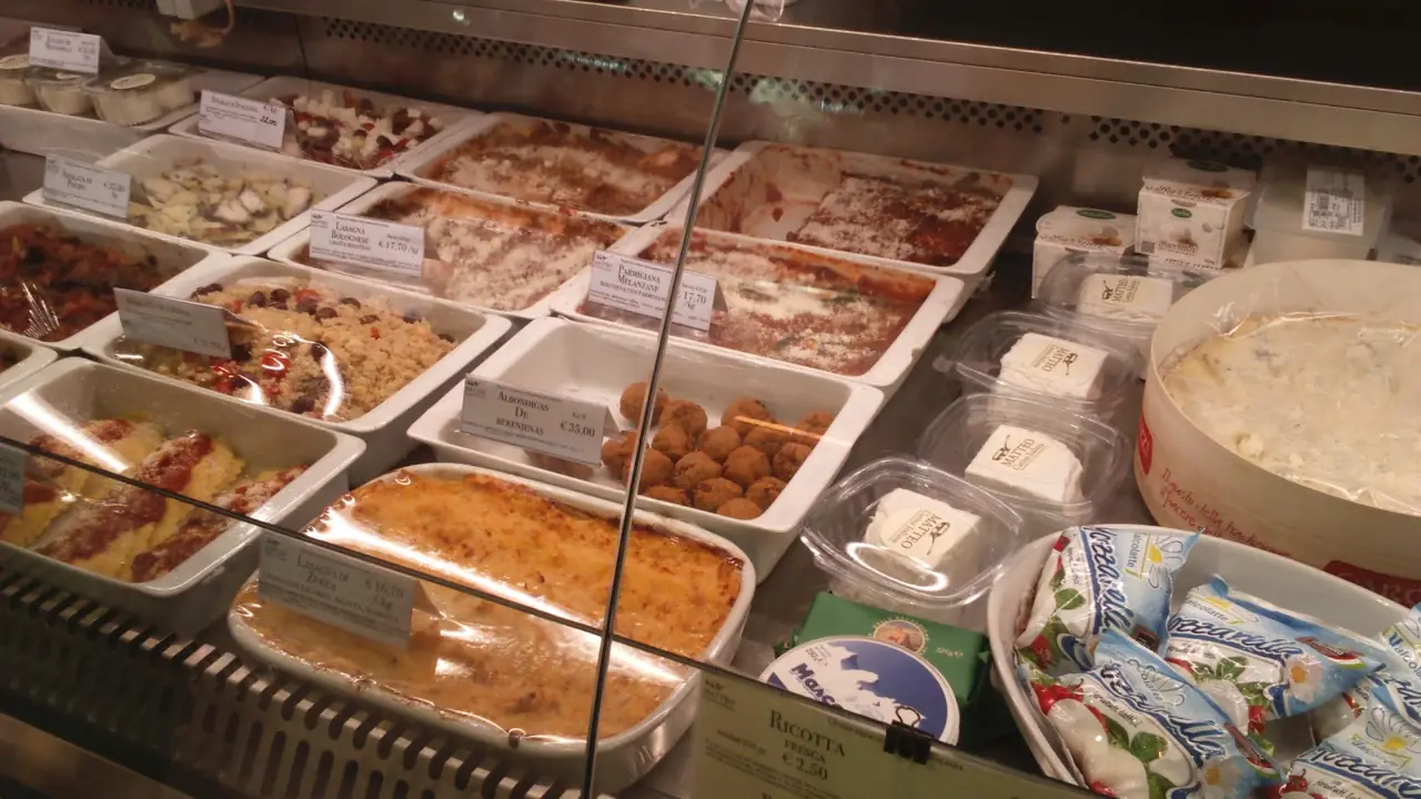 Deli case of prepared Italian dishes - lasagna, eggplant parmigiana, arancini and cheeses