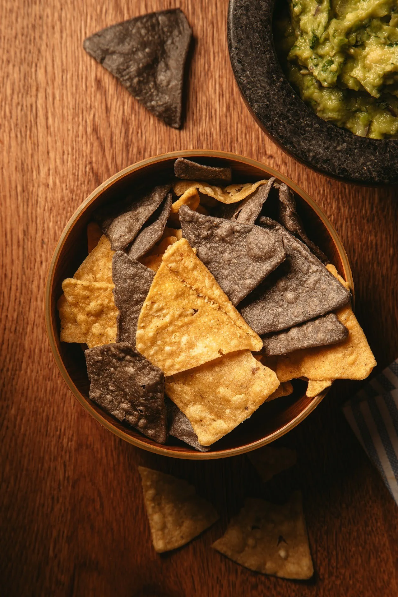 A bowl of tortilla chips on a wooden table