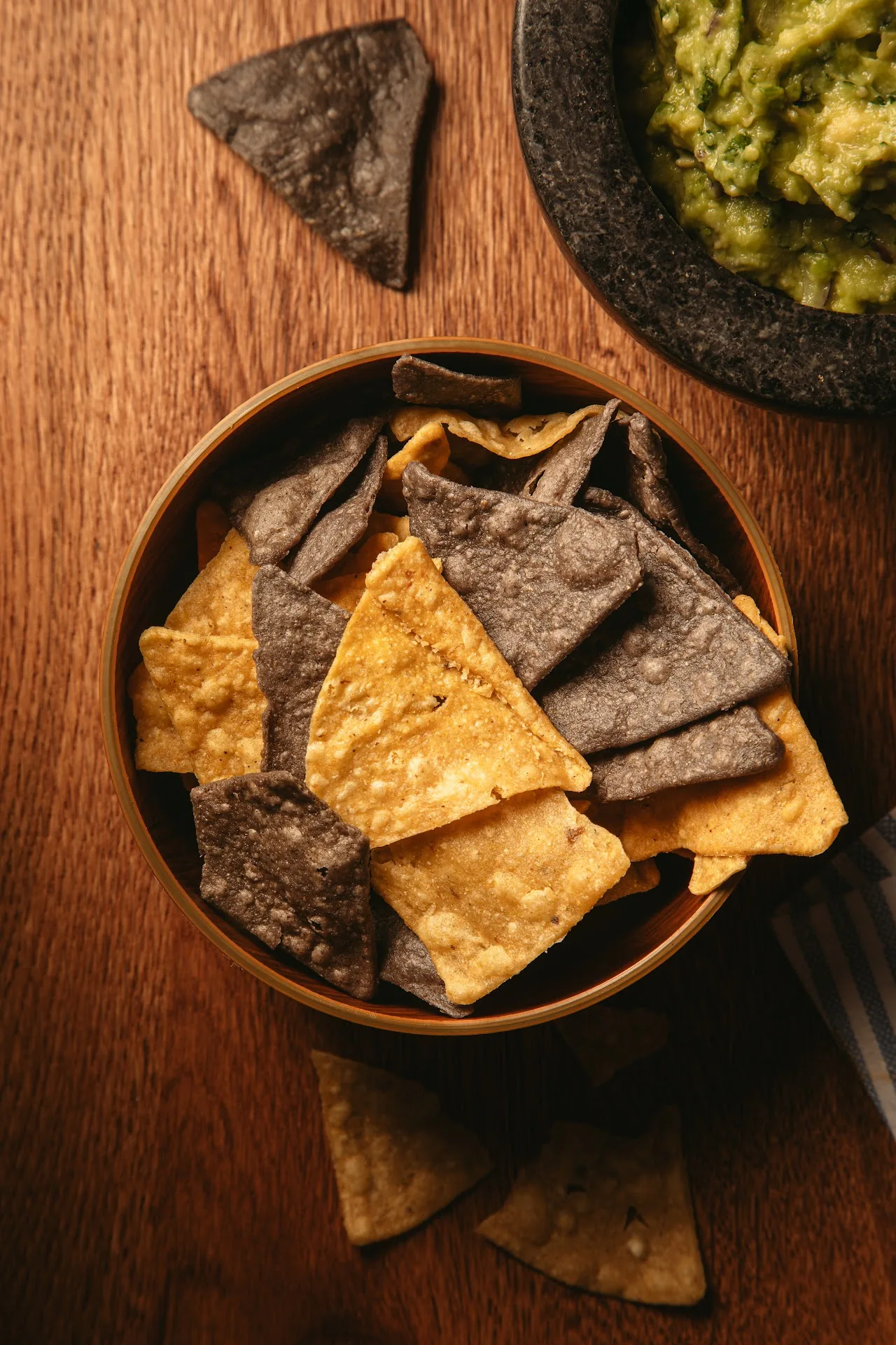A bowl of tortilla chips with a side of guacamole