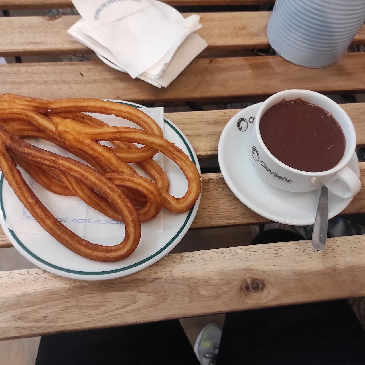 A plate of churros beside a cup of hot chocolate