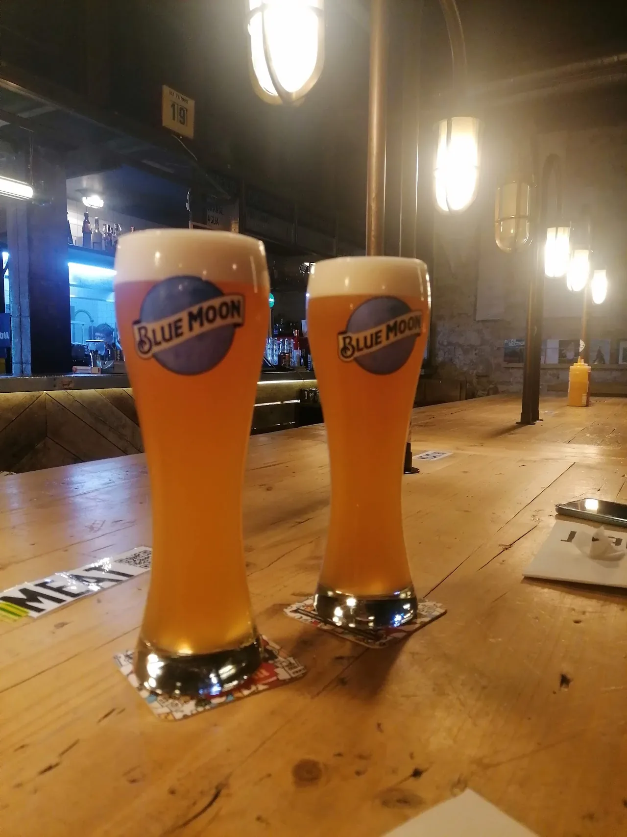 Two glasses of wheat beer on a wooden table
