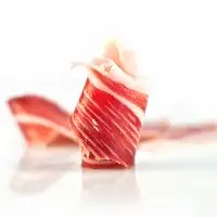 Rolled slices of marbled Iberian cured ham on a bright white background