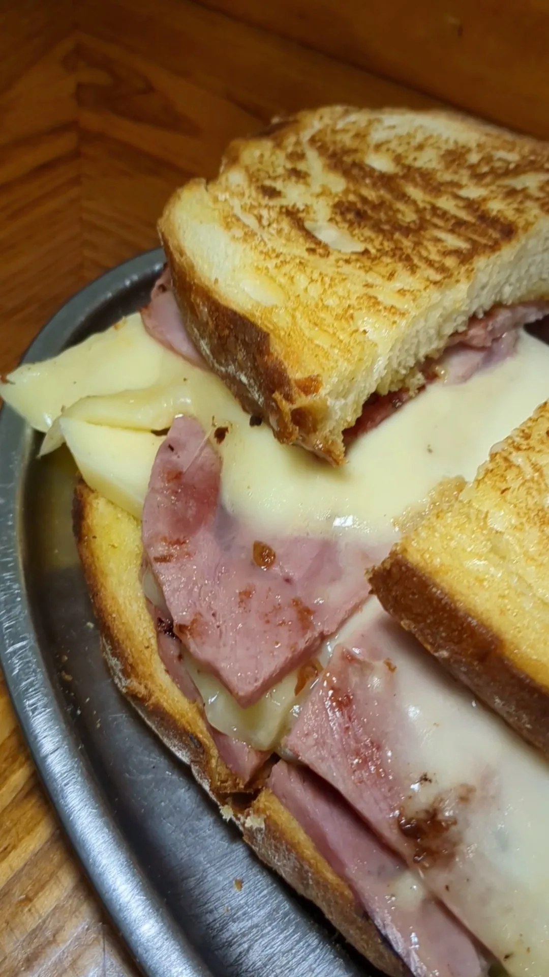 A grilled ham and cheese sandwich cut in half