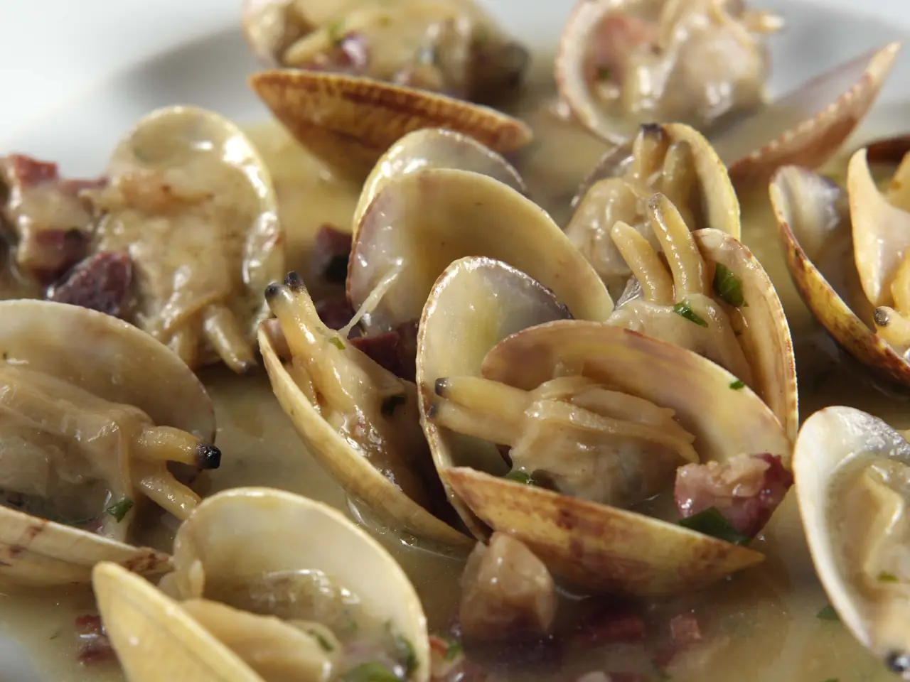 Clams cooked in a garlicky white wine sauce with diced jamón and parsley at Merendero de La Mari
