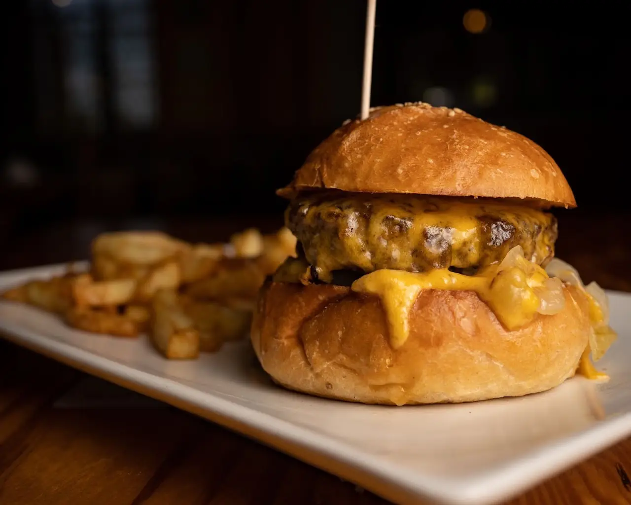 Cheeseburger with melted cheese on a brioche bun, served with fries