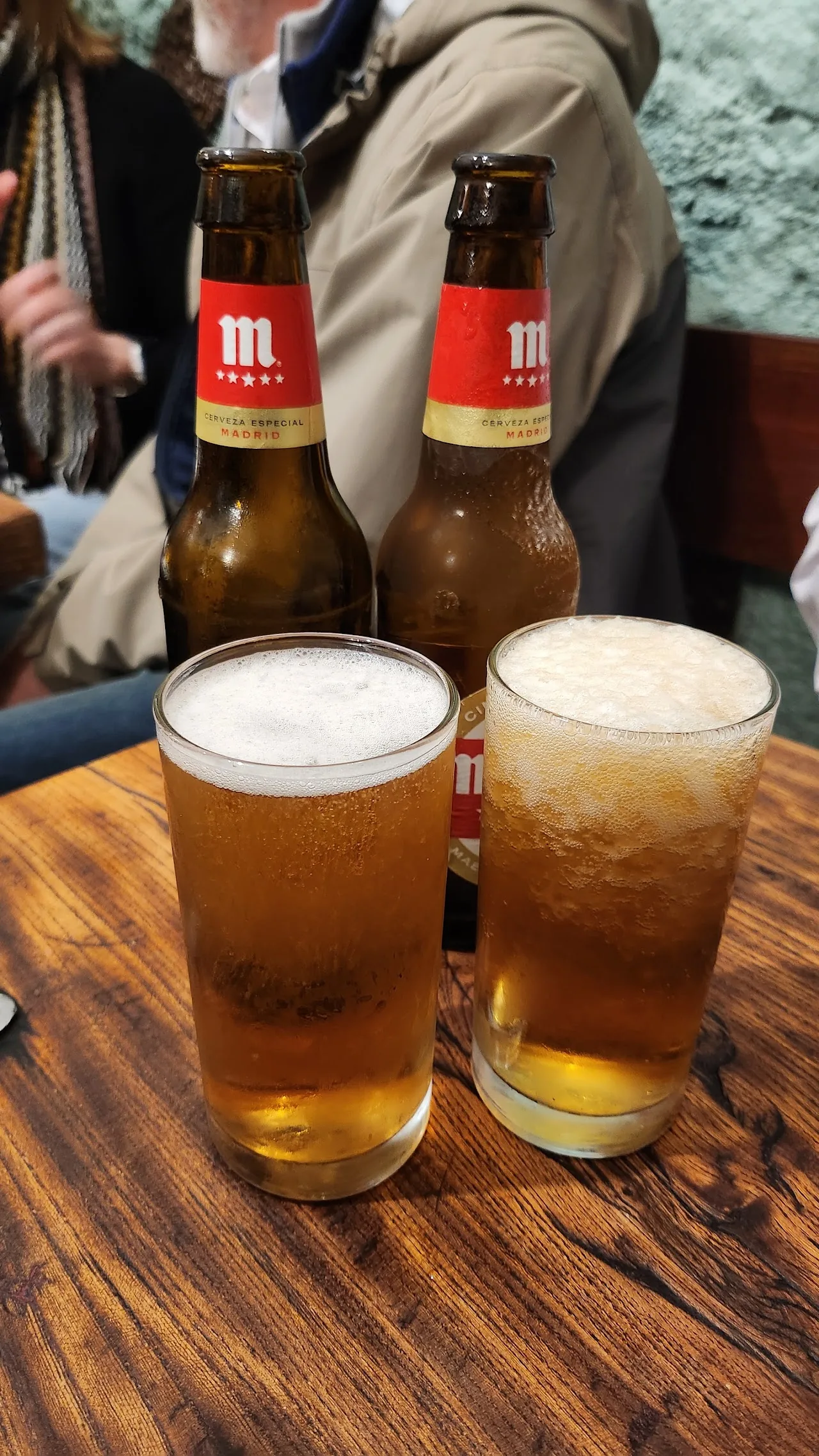 Two glasses of beer on a wooden table