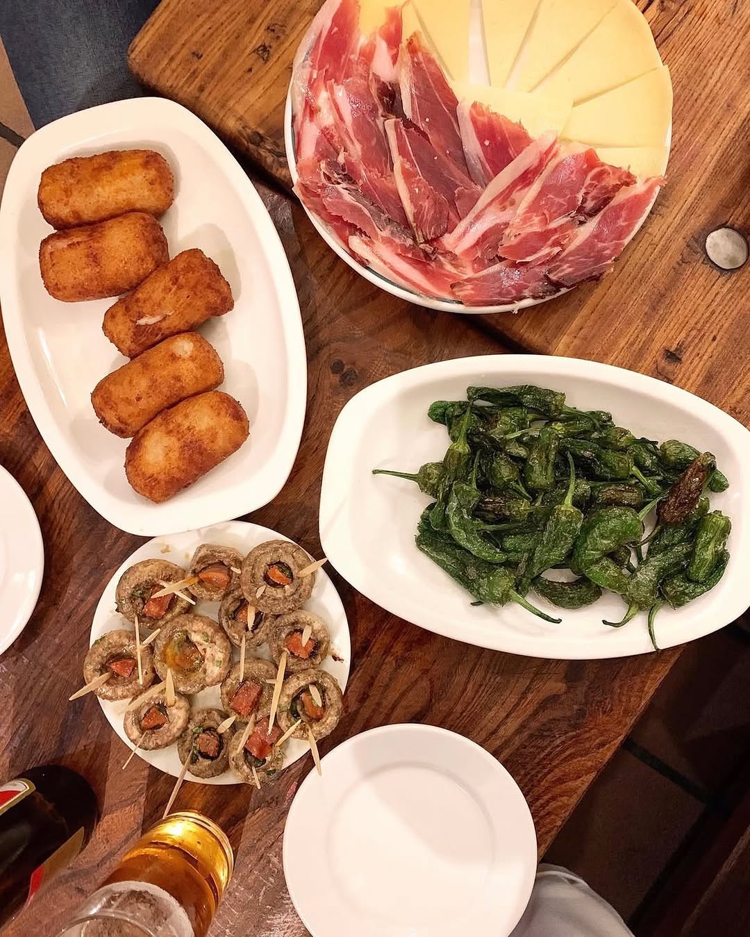 Aquí no falta de na’: croquetas caseras, su tabla de jamón y queso, unos pimientos de Padrón que unos pican y otros no,