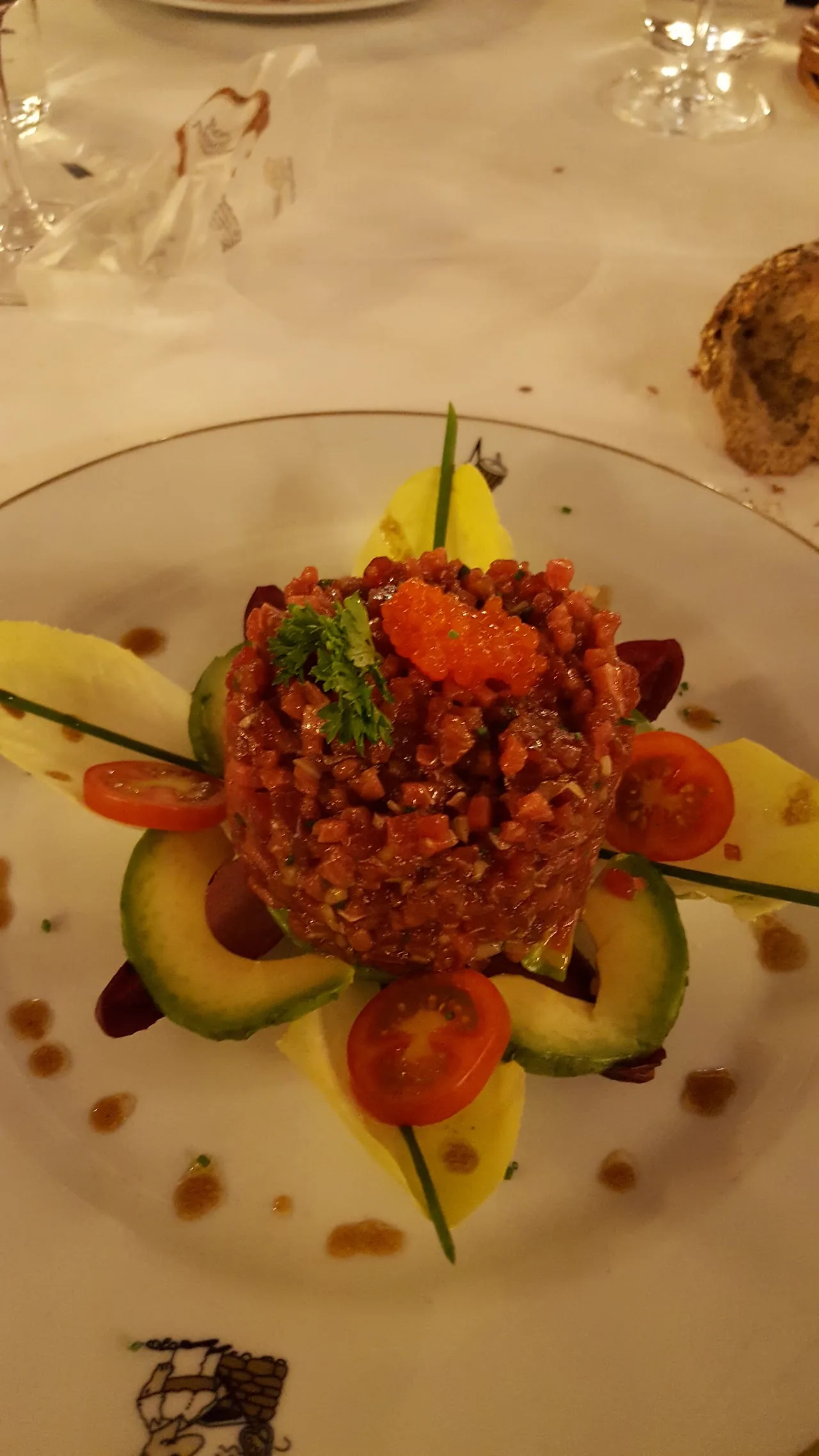 A beef tartare plated with cucumber ribbons and citrus dots