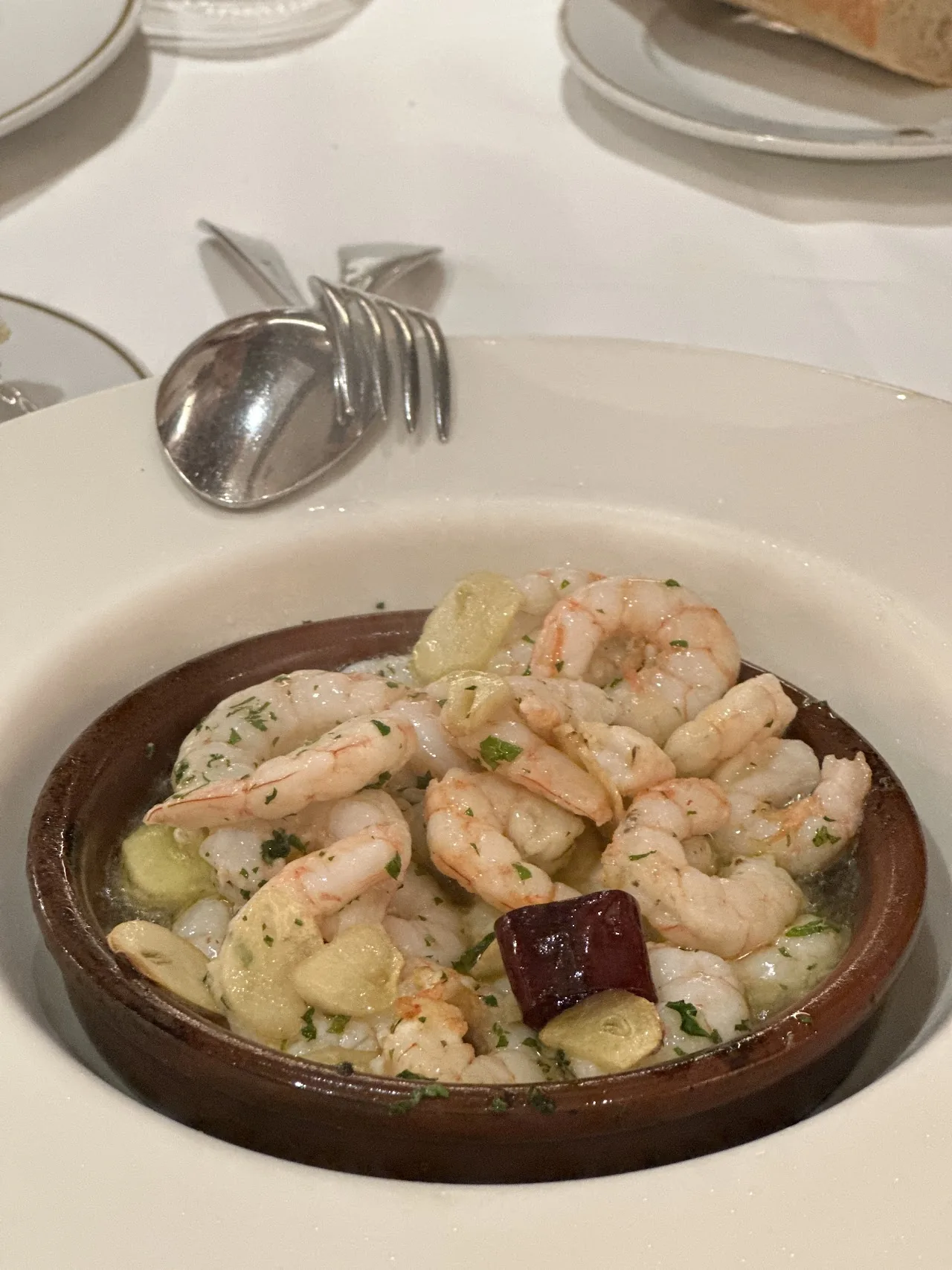 A clay dish of sautéed shrimp with garlic