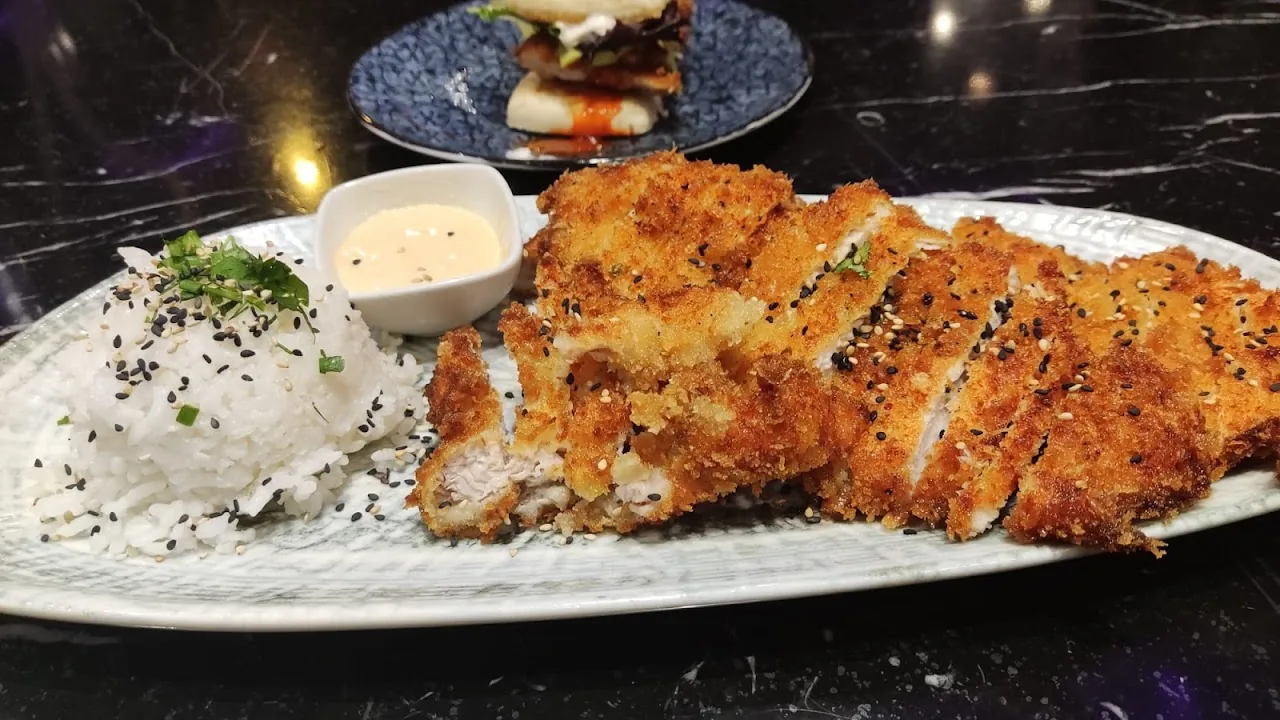 A plated dish of crispy chicken katsu strips with dipping sauces