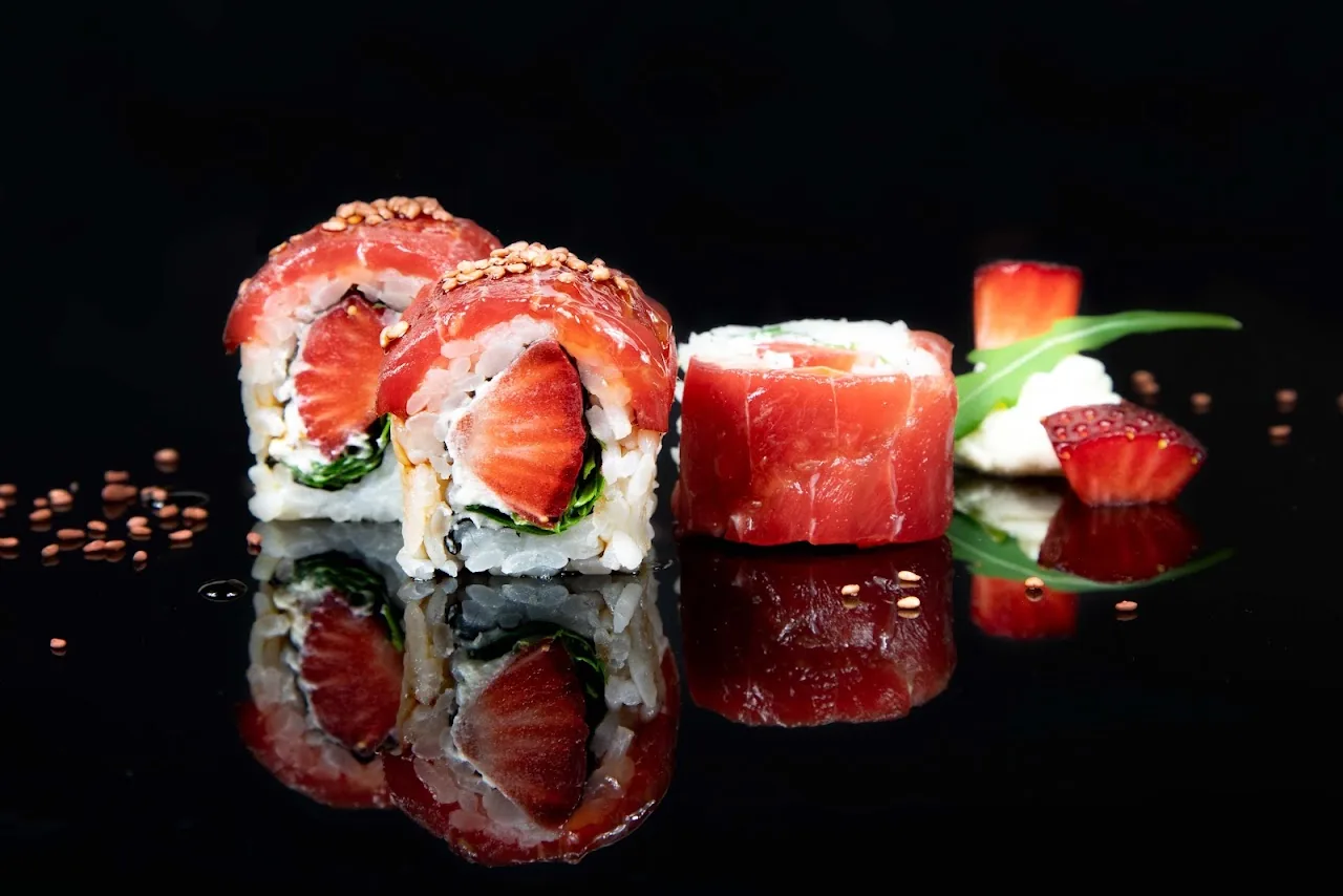 Sushi rolls garnished with fresh strawberry slices