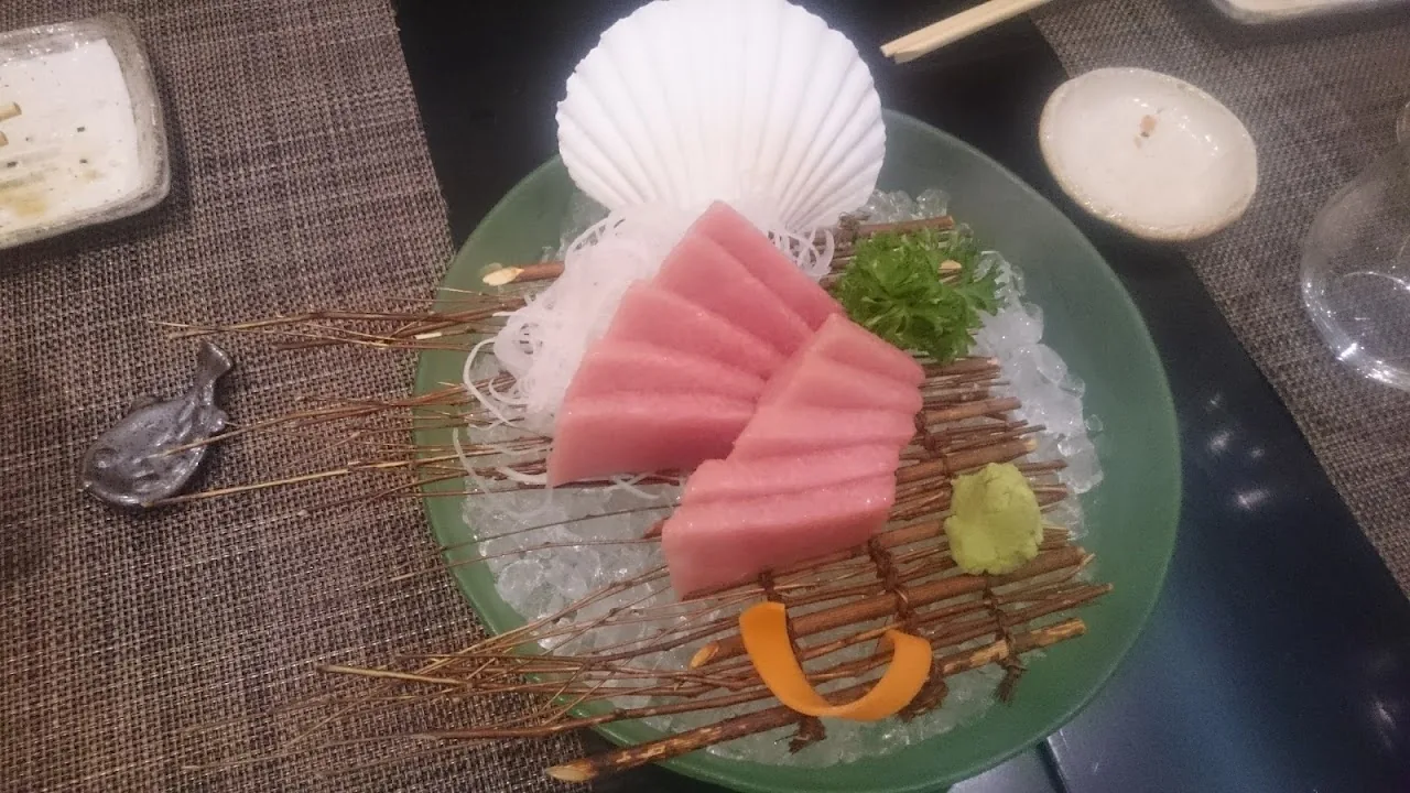 Tuna sashimi skewers served over shredded daikon in a shell dish