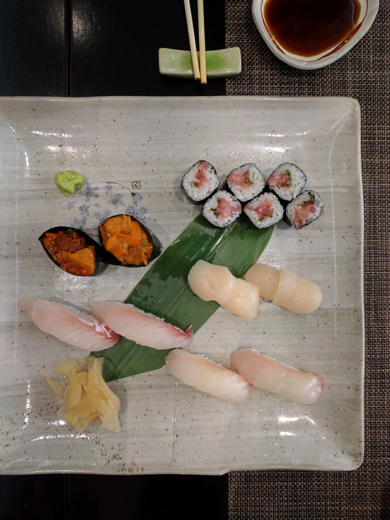 A platter of assorted sushi and nigiri with wasabi and pickled ginger