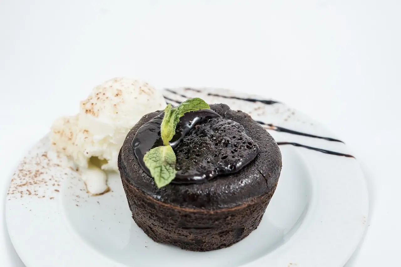A chocolate lava cake with a scoop of vanilla ice cream and mint garnish.