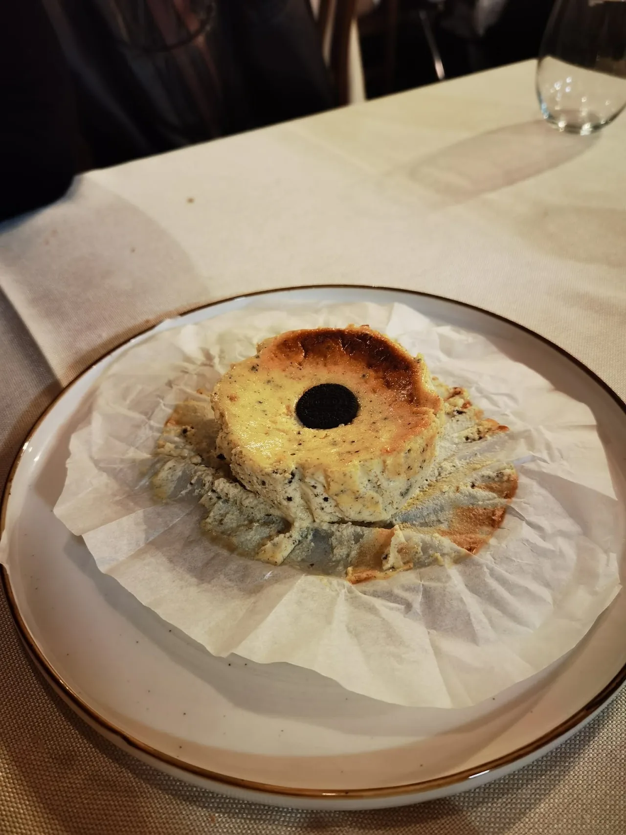 A savory tart or quiche on a paper-lined plate