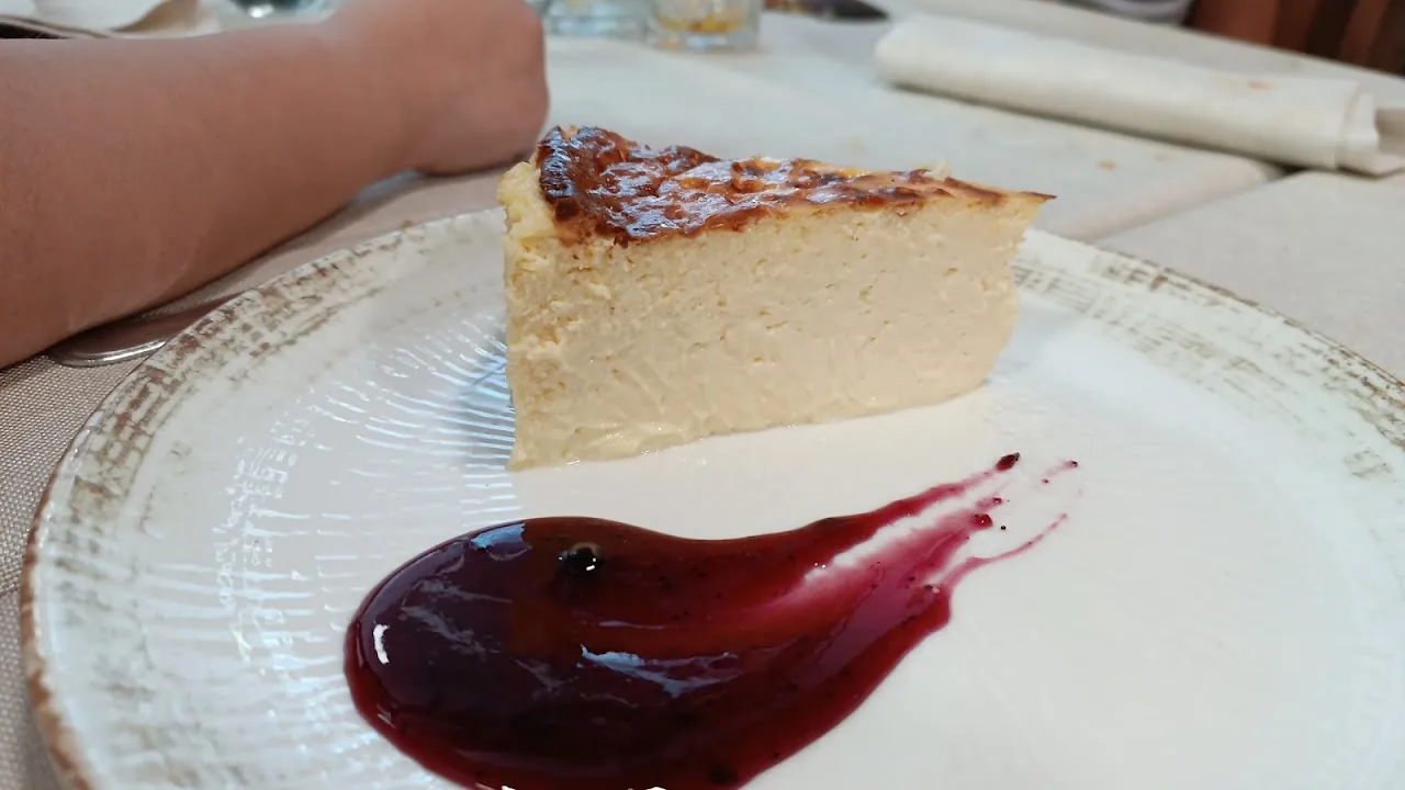 A slice of cheesecake with berry sauce on a white plate