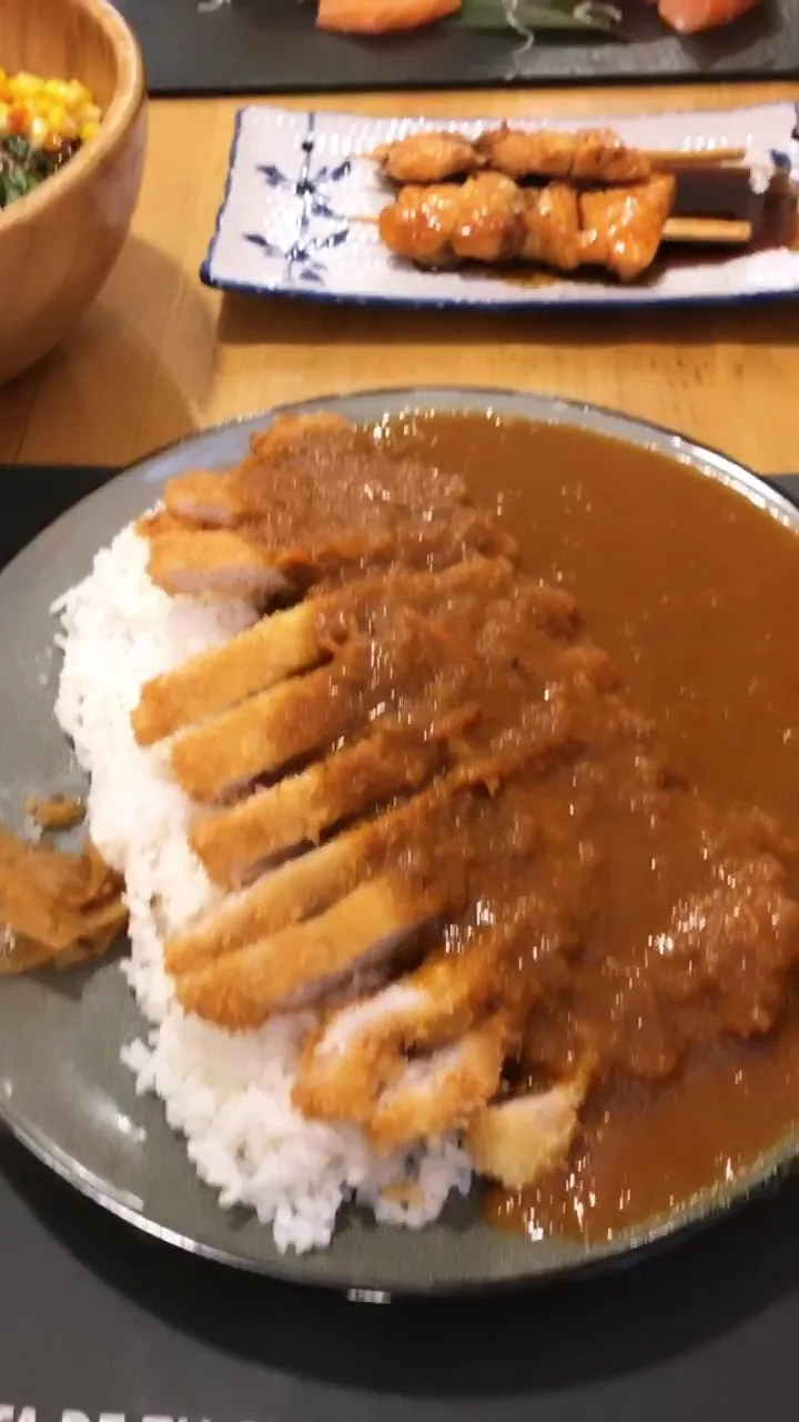 A plate of sliced pork katsu over curry rice