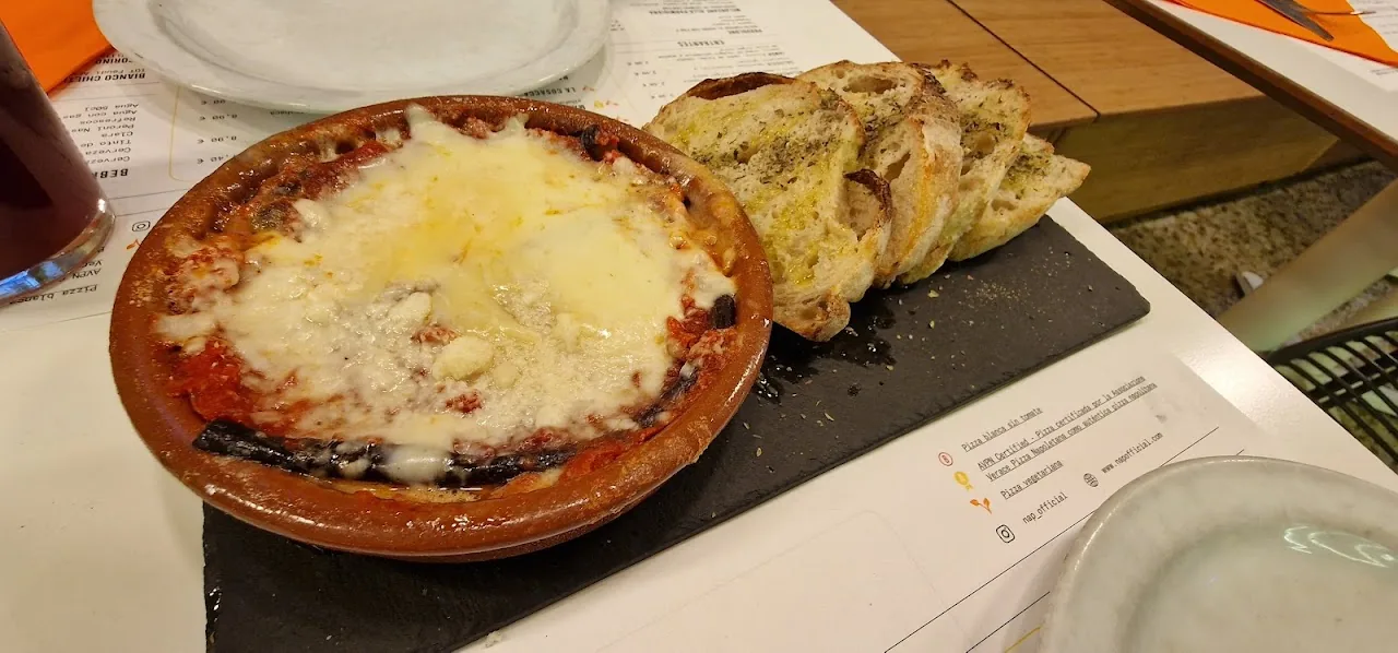 A terracotta dish of melted cheese with bread on the side