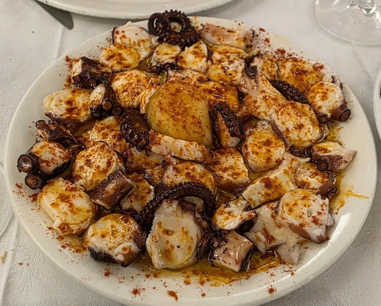 A plate of octopus pieces with paprika and potatoes