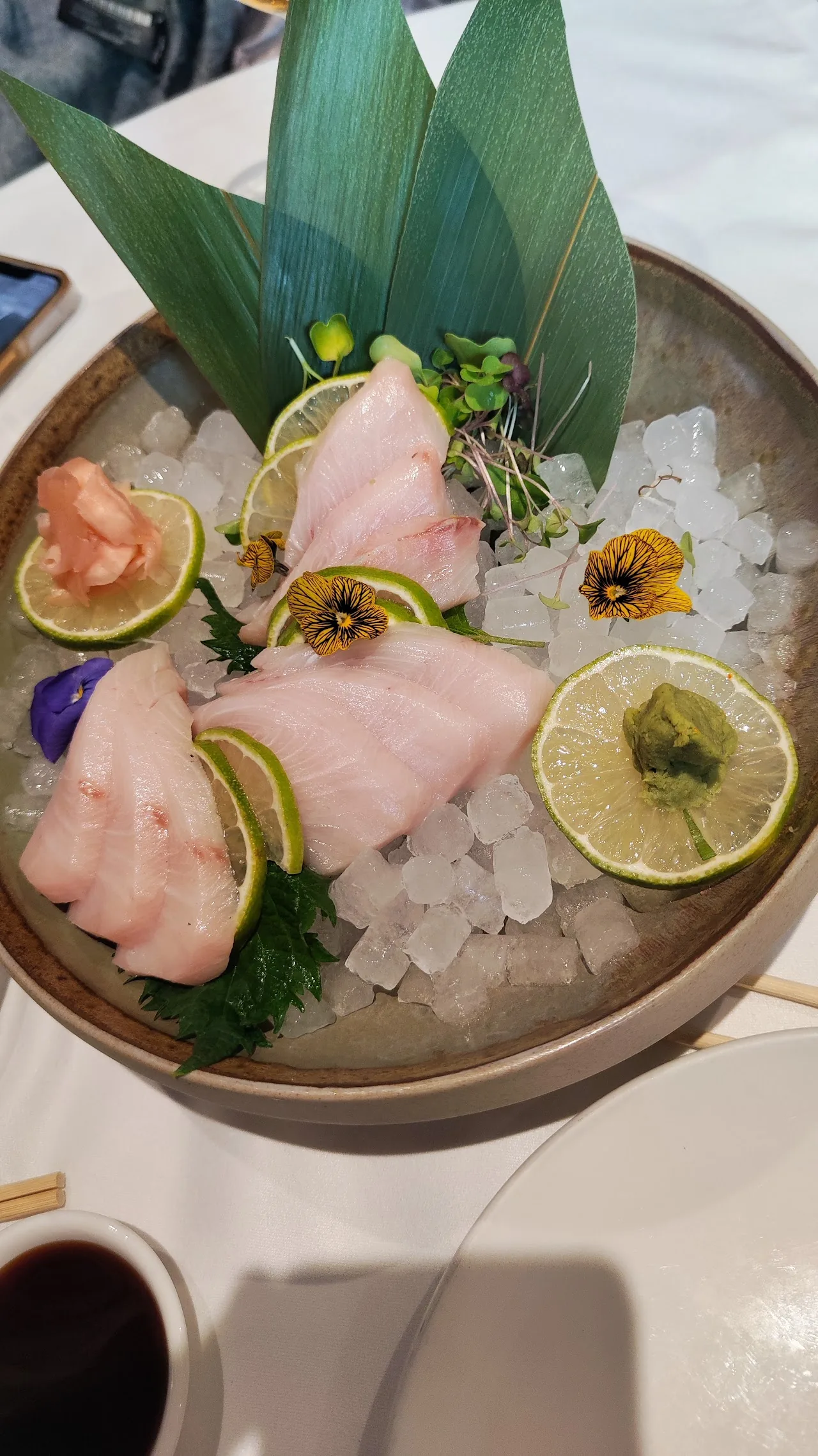 A sashimi platter of assorted fish served over ice with citrus