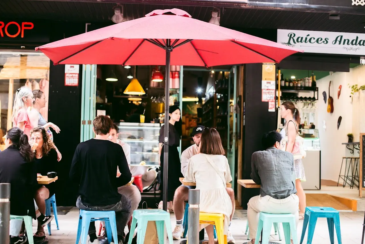 Stools and a parasol on the café's terrace beside the Mercat de l'Olivar