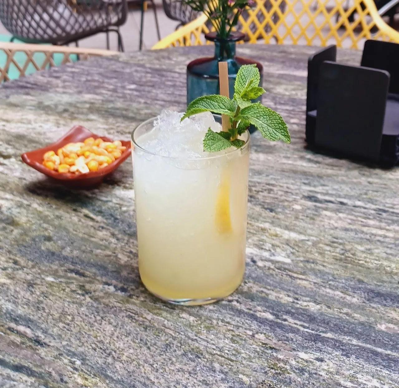 A cocktail garnished with mint in a rocks glass