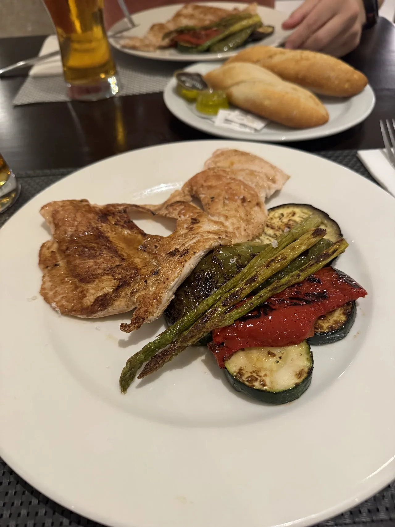 A plate of grilled ribs, sausage and vegetables