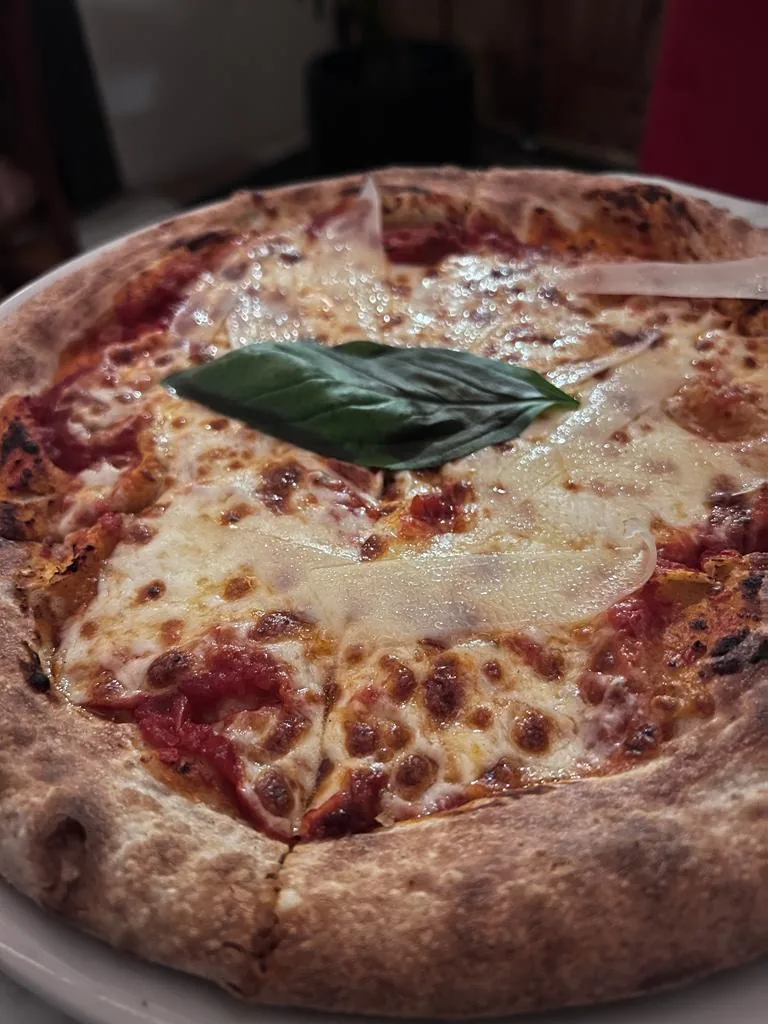 A basil-topped pizza with melted cheese