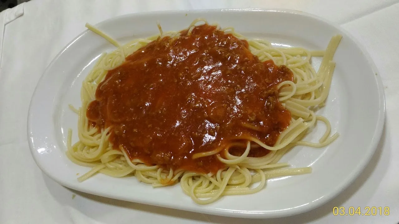 A plate of spaghetti topped with a red tomato sauce