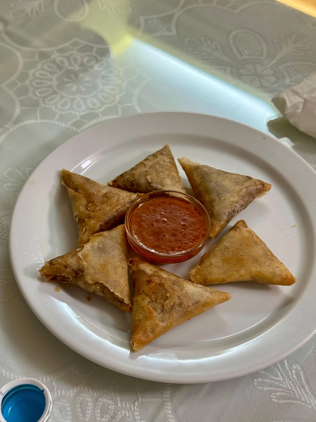 Fried samosas arranged around a red dipping sauce