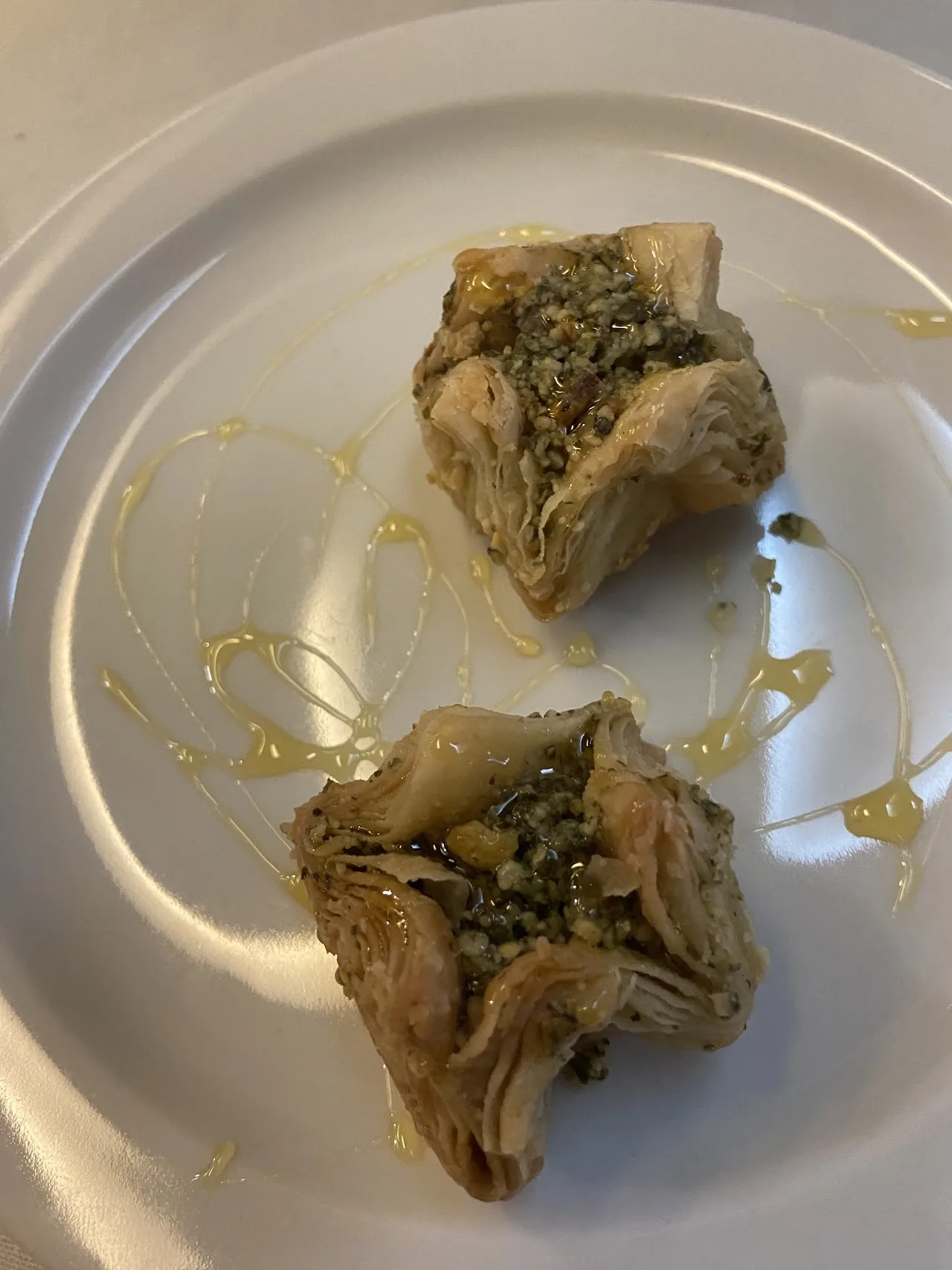 Two pastries drizzled with honey on a plate