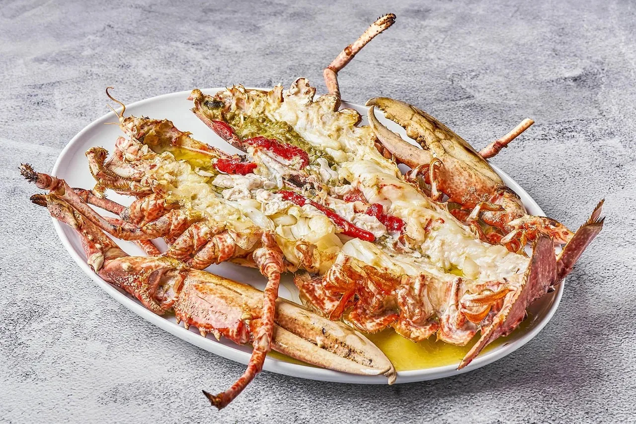 A split lobster with butter on an oval plate