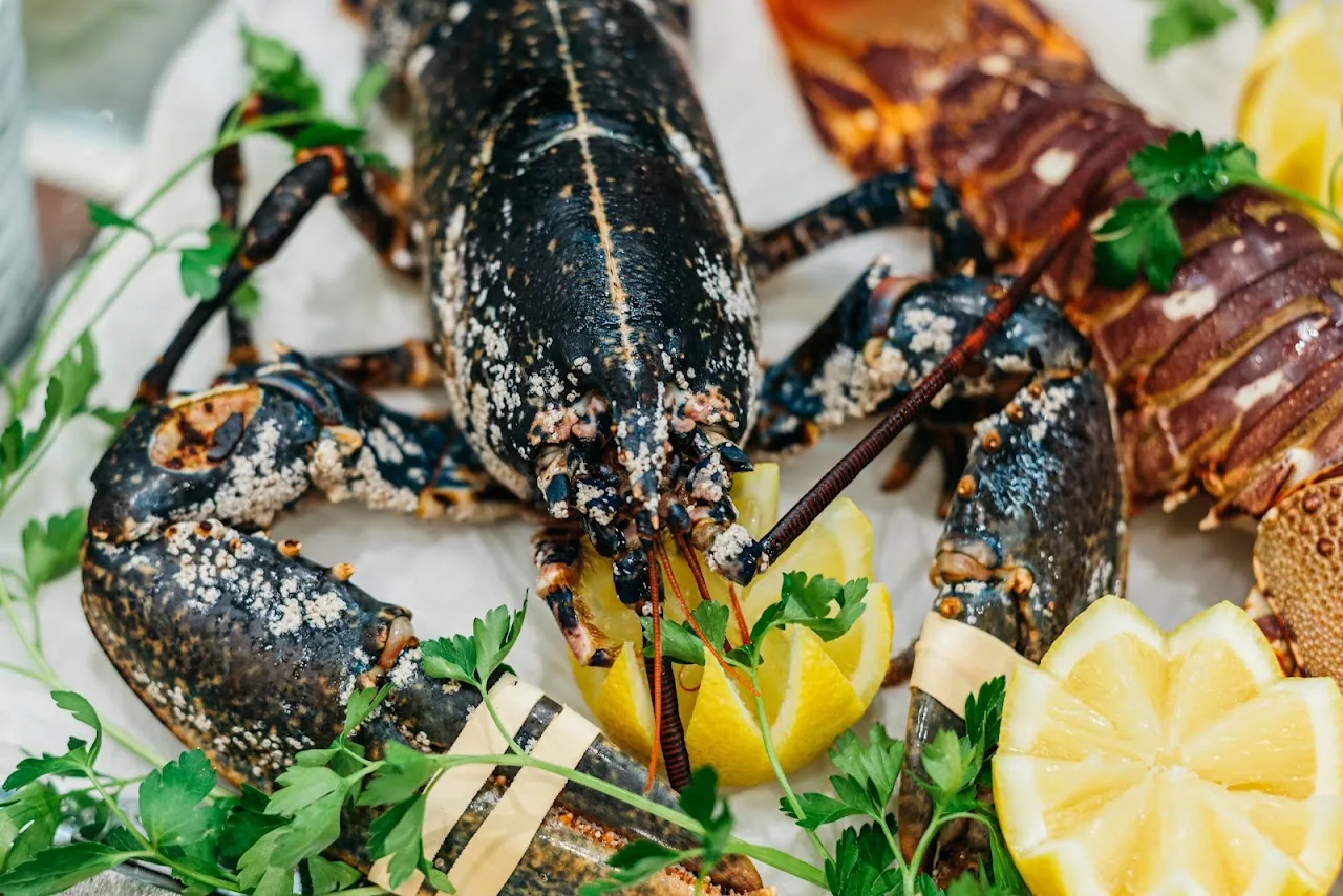 Grilled lobster halves plated with lemon wedges