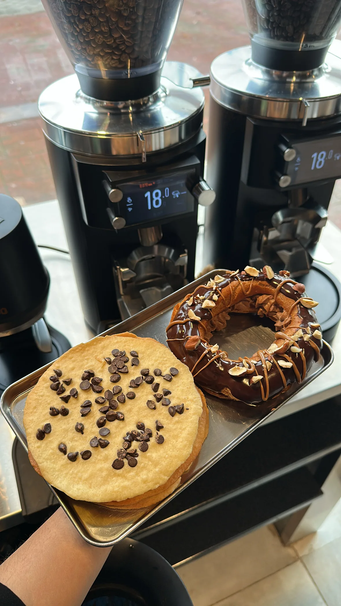 A cookie and a chocolate-drizzled donut on a small tray