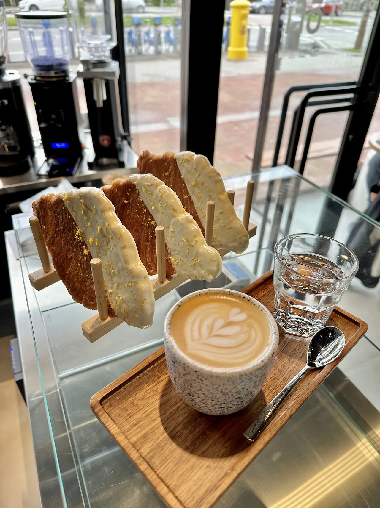 Slices of toast beside a latte on a wooden board
